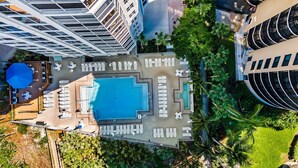 An aerial view of a hotel with a central swimming pool surrounded by sun loungers and a covered seating area. - Gullwing 405 by Distinctive Beach Rentals (Fort Myers Beach)