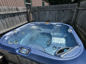 Un jacuzzi con panel de control, rodeado por una valla de madera.