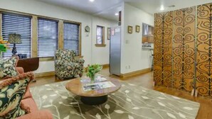 A living room with a sofa, a coffee table, and a decorative partition. - Evie's apartment (Oklahoma City)