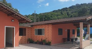 Un edifici amb teulada de rajola, parets de maó i un porxo cobert amb zones d'estar a l'aire lliure.
