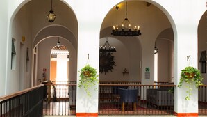 Ein Korridor mit Bögen, hängenden Pflanzen und einer Chandelier.