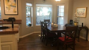 Uma sala de jantar com mesa de madeira, cadeiras e um lustre.