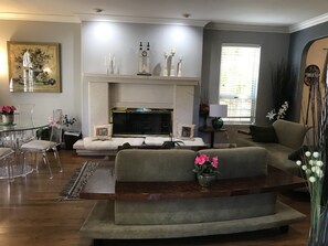 Uma sala de estar com lareira, sofá e televisão.