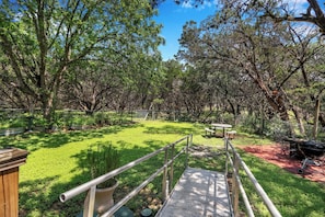 A park with a wooden deck, metal railings, and picnic tables. - Charming 2 bedroom house in the heart of Downtown Wimberley! Walk to the Square! (Wimberley)