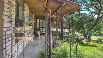 A stone building with a wooden porch, a metal gate, and a sign reading 'Entrance'.