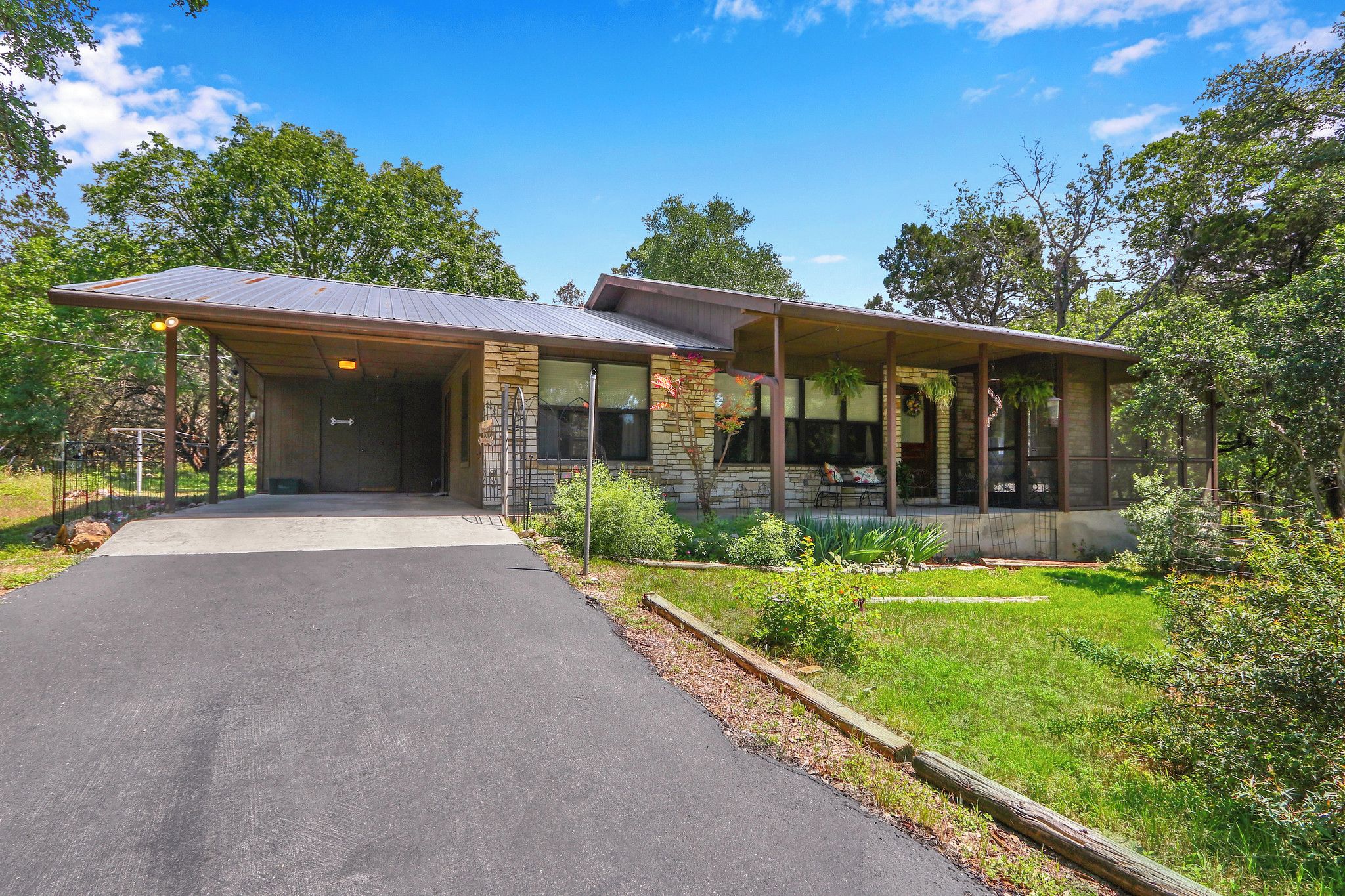 A two-story building with a covered porch and a paved driveway.