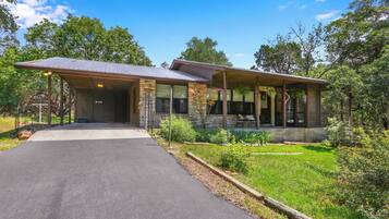 A two-story building with a covered porch and a paved driveway.