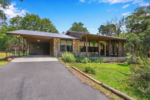 A two-story building with a covered porch and a paved driveway.