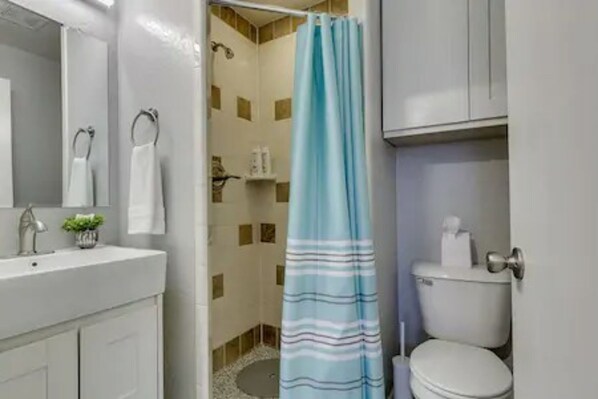 A bathroom with a shower, toilet, and sink. - Garage Studio near OUSHC Hospital (Oklahoma City)