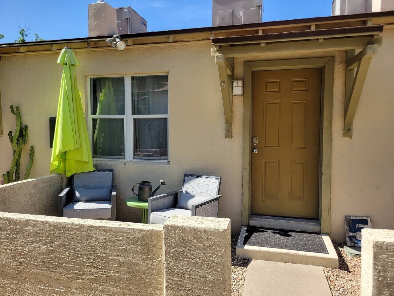 A house with a door, a window, and outdoor seating.