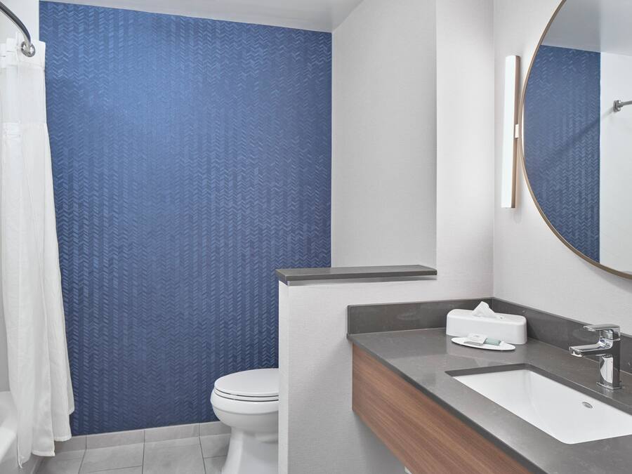 A modern bathroom with a shower, toilet, and sink.