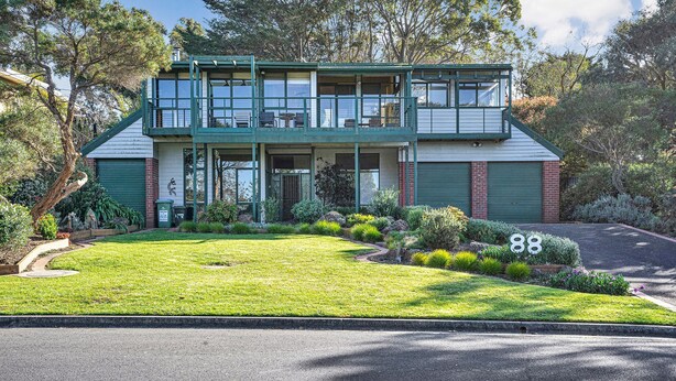 A two-story house with a front porch, a garage, and a well-maintained lawn. - SOMETHING FOR EVERYONE (Somers)