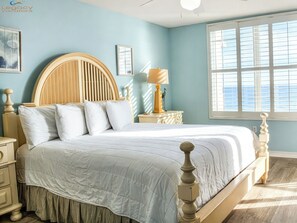 A bedroom with a bed, nightstands, a lamp, and a window with blinds. - Island Princess 507 Amazing Views + Beach Service + Assigned Covered Parking! (Fort Walton Beach)