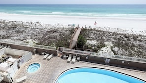 A pool area with a view of the beach and ocean.