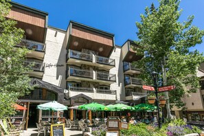 Un hôtel doté d’une terrasse, une enseigne indiquant « Mark West » et des panneaux de signalisation indiquant le « sentier de Gore Valley » et l’« arrêt de bus Est ».