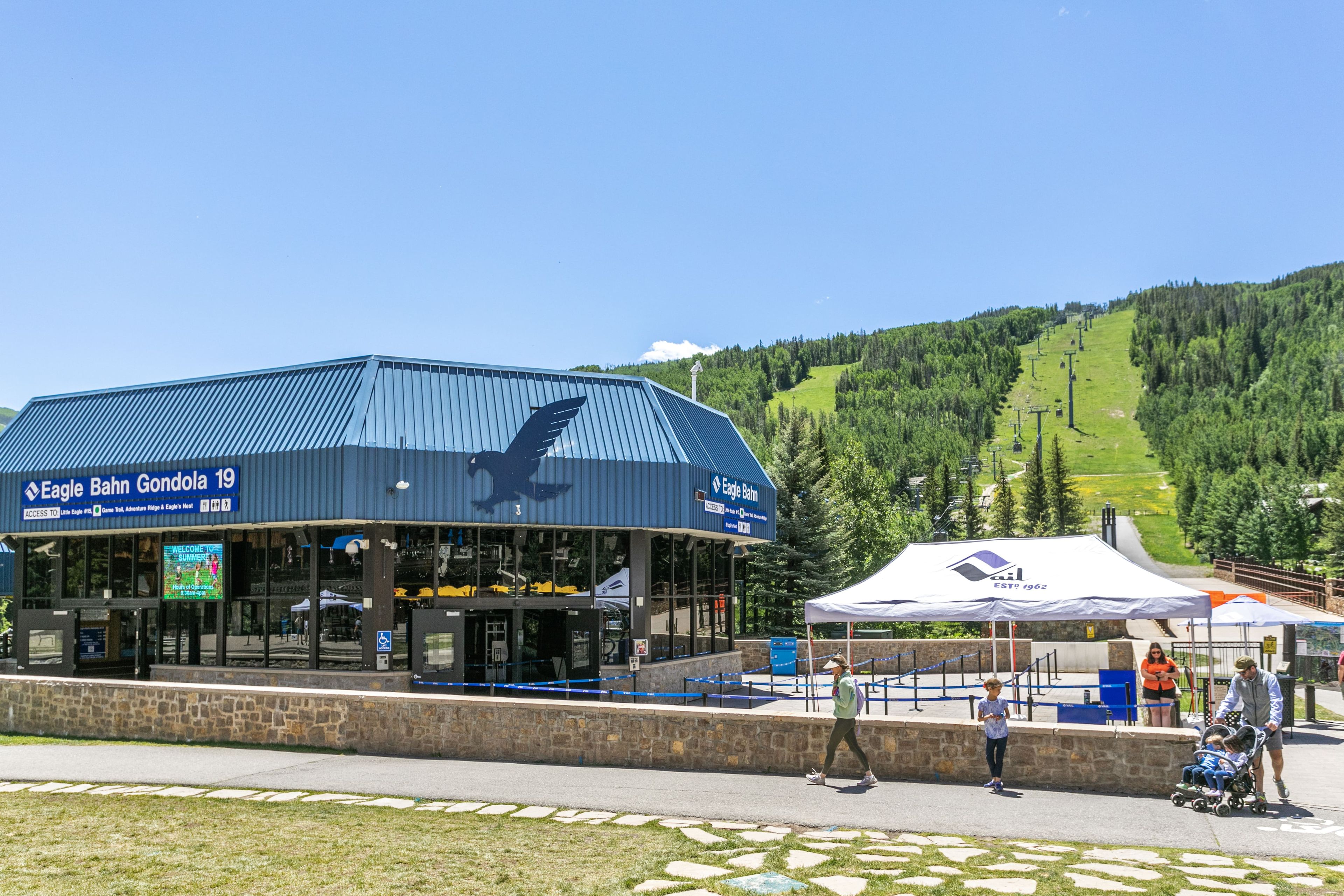 A ski resort building with a blue roof and a ski lift visible in the background.