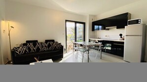A modern kitchen with a dining area, a sofa, and a refrigerator. - MARINA D'ORU - Comfortable studio in town center (M) (PROPRIANO)