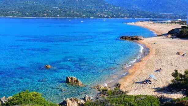 A coastal beach with clear blue waters, rocky shoreline, and mountains in the background. - MARINA D'ORU - Comfortable studio in town center (M) (PROPRIANO)