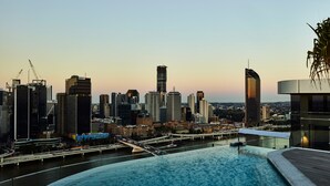 A city skyline with modern buildings and a waterfront pool area. - Lucid Living Brisbane (South Brisbane)
