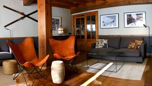A cozy living room with a sofa, two leather chairs, a coffee table, and a wooden floor. - Lo Paller (Alt Aneu)