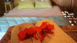 Una cama con un almohadón verde y un cabecero de madera.