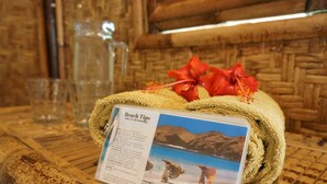 Una mesa de madera con una toalla enrollada y un cartel con consejos para la playa.