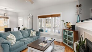 A living room with a sofa, coffee table, and a fireplace.