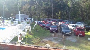 Ein Parkplatz mit mehreren Autos und einem kleinen Poolbereich mit Liegestühlen.