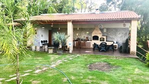 Ein Haus mit Terrasse, Grill und kleinem Garten.