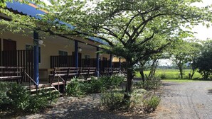 A building with a covered outdoor seating area, a gravel path, and surrounding greenery. - Ban Chomlay Resort Satun (La-ngu)
