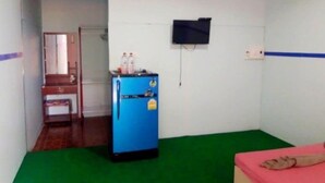 A room with a blue cabinet, a television mounted on the wall, and a green carpet. - Ban Chomlay Resort Satun (La-ngu)