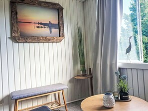 A room with a wooden bench, a framed picture, a potted plant, and a table with decorative items. - Beautiful apartment for 3 guests with WIFI, TV, balcony and pets allowed (Stralsund)