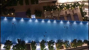 An aerial view of a large indoor swimming pool with multiple lanes, surrounded by trees and seating areas. - The Robertson Suites Bukit Bintang (Kuala Lumpur)