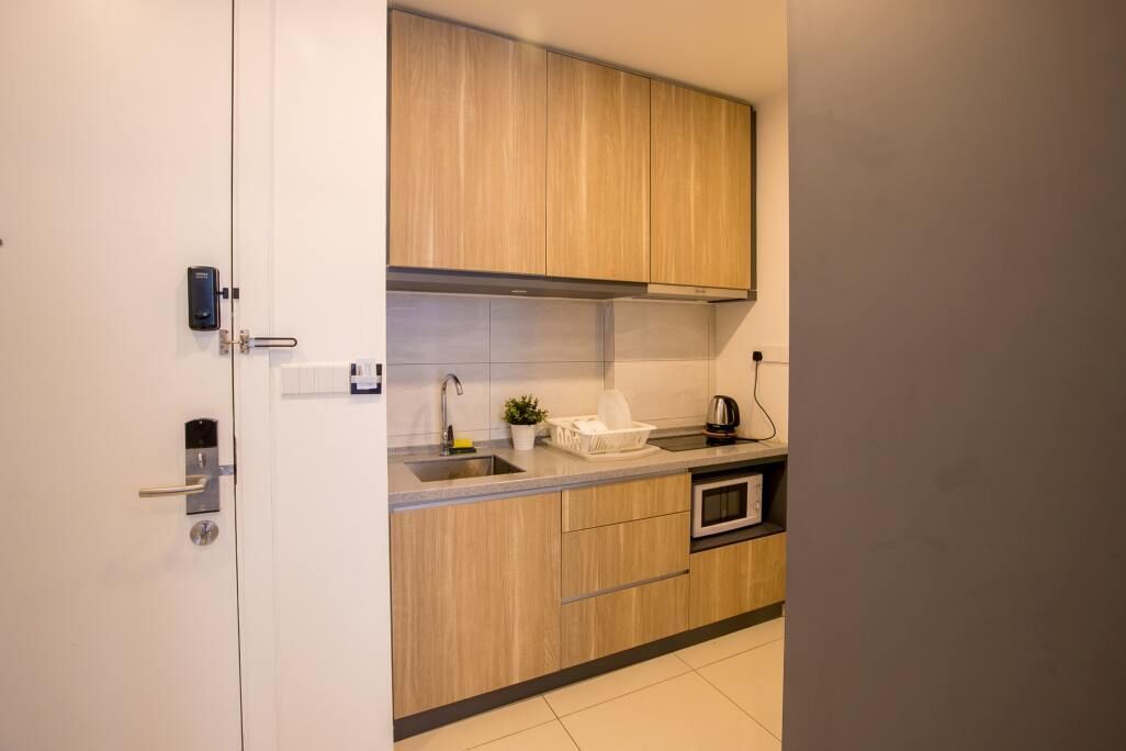 Una cocina moderna con armarios de madera, un lavamanos de acero inoxidable y un horno empotrado.