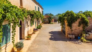 A narrow alleyway flanked by buildings with green shutters and vines. - Wonderful private villa for 6 people with private pool, A/C, WIFI, TV and terrace (Felanitx)
