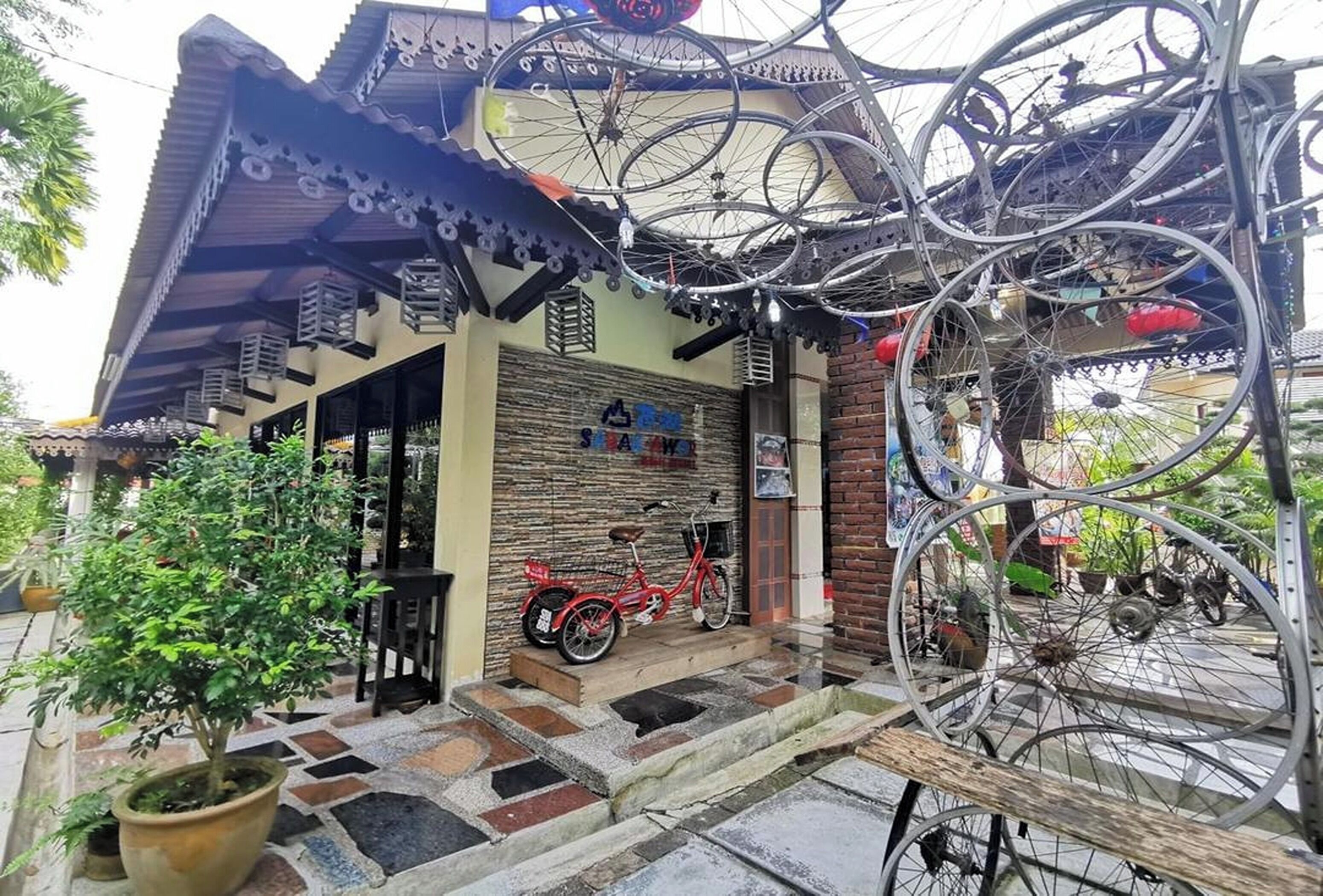 Une maison traditionnelle avec un toit en tuiles, un porche en bois et un vélo garé devant.