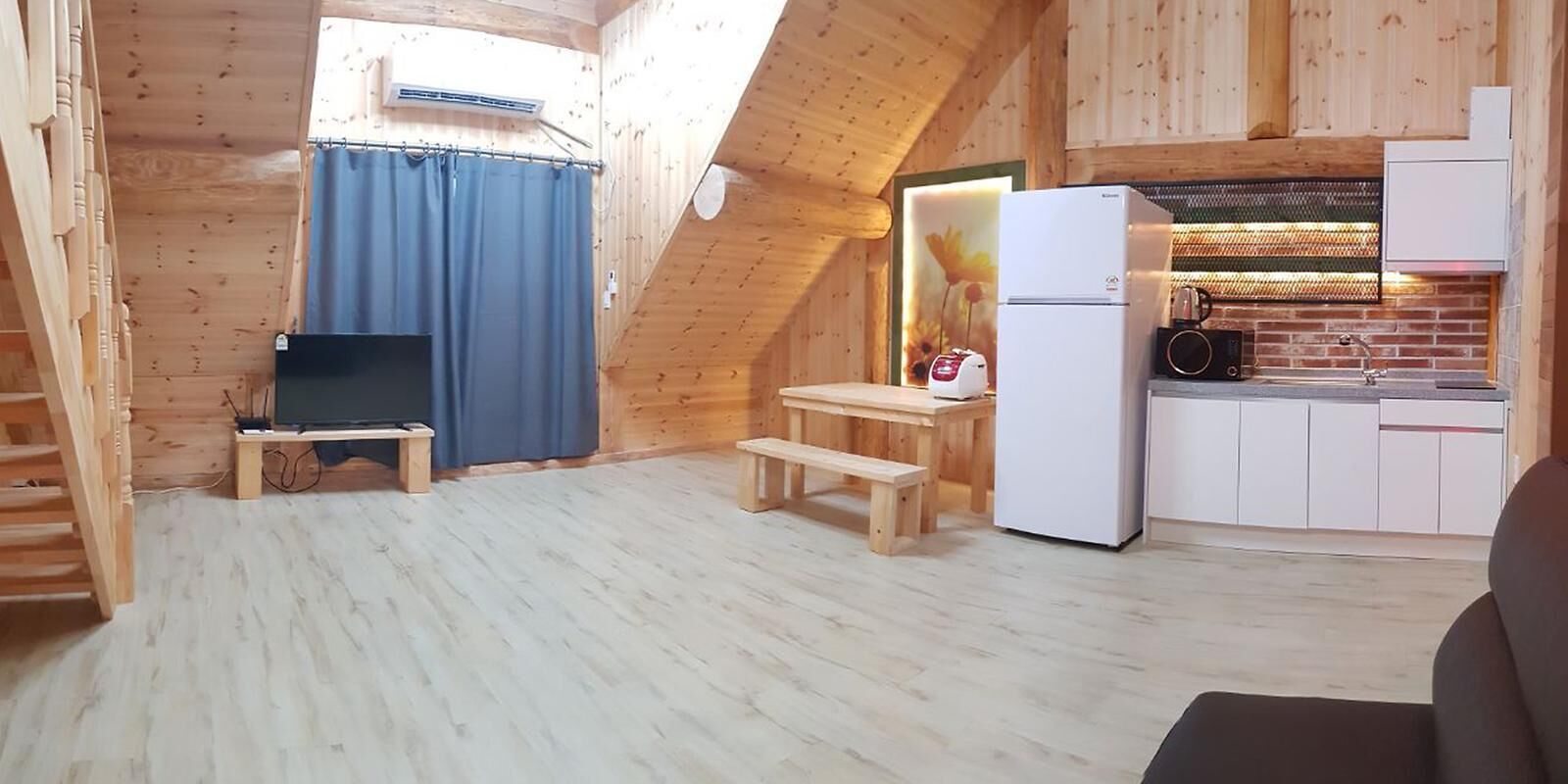 Et lille køkken med køleskab, komfur og vask.