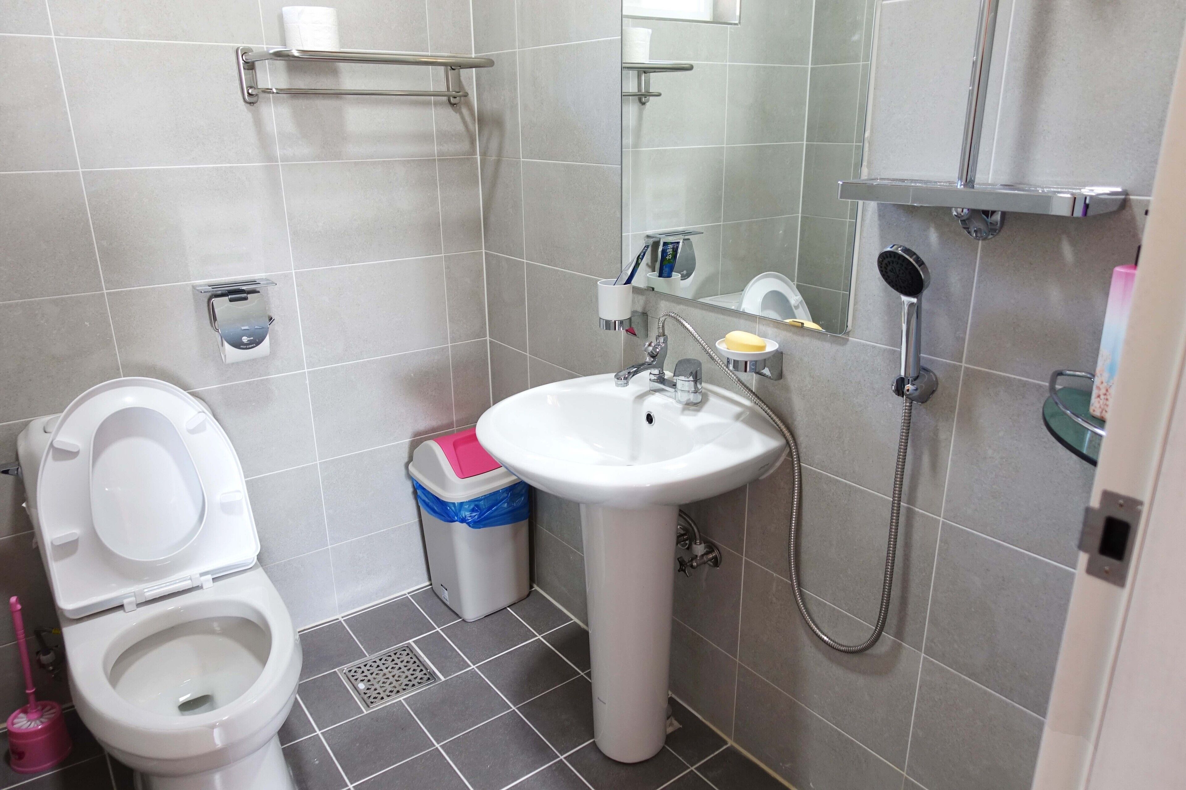 A bathroom with a toilet, sink, and shower.