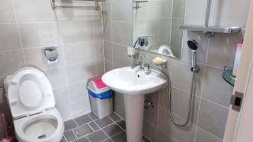 A bathroom with a toilet, sink, and shower.