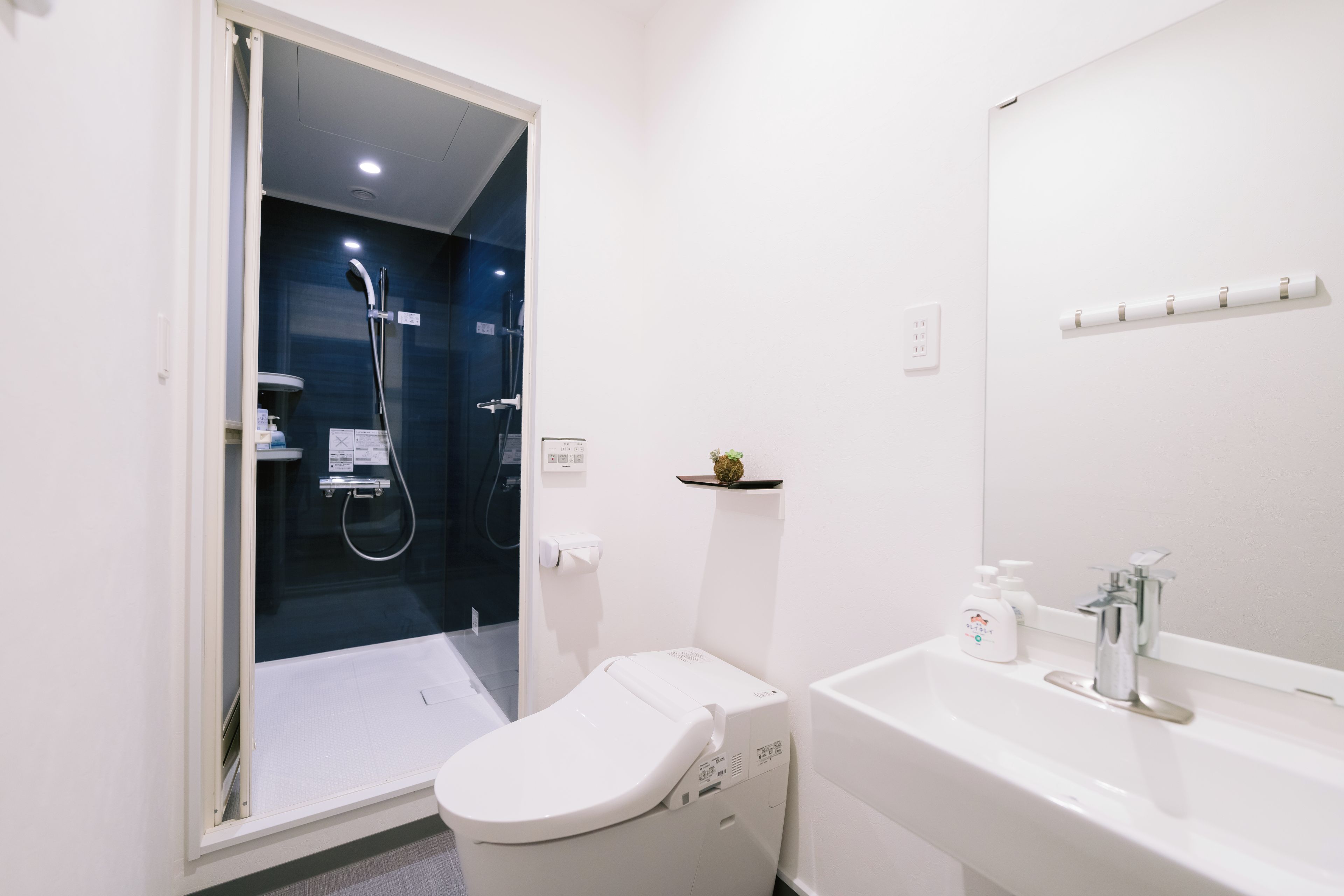 Un baño moderno con inodoro, lavabo y cabina de ducha.