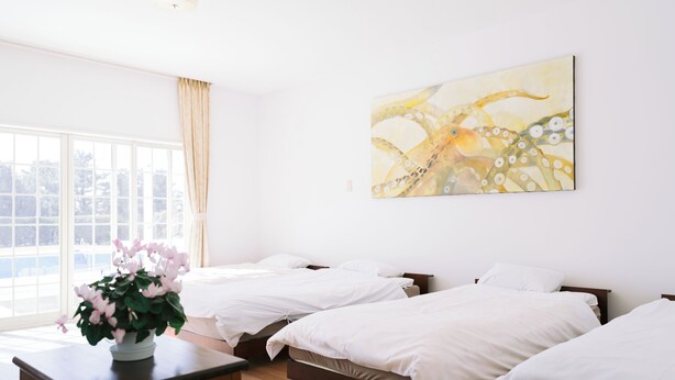 A hotel room with three beds, a large window, and a painting on the wall. - Hotel Kailani (Oshima)