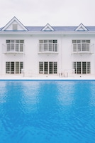 Un edificio de dos pisos con una piscina delantera.