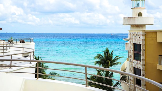 A balcony with a view of the ocean and a lighthouse. - Corto Maltes 301 waterfront apartment (Playa del Carmen)