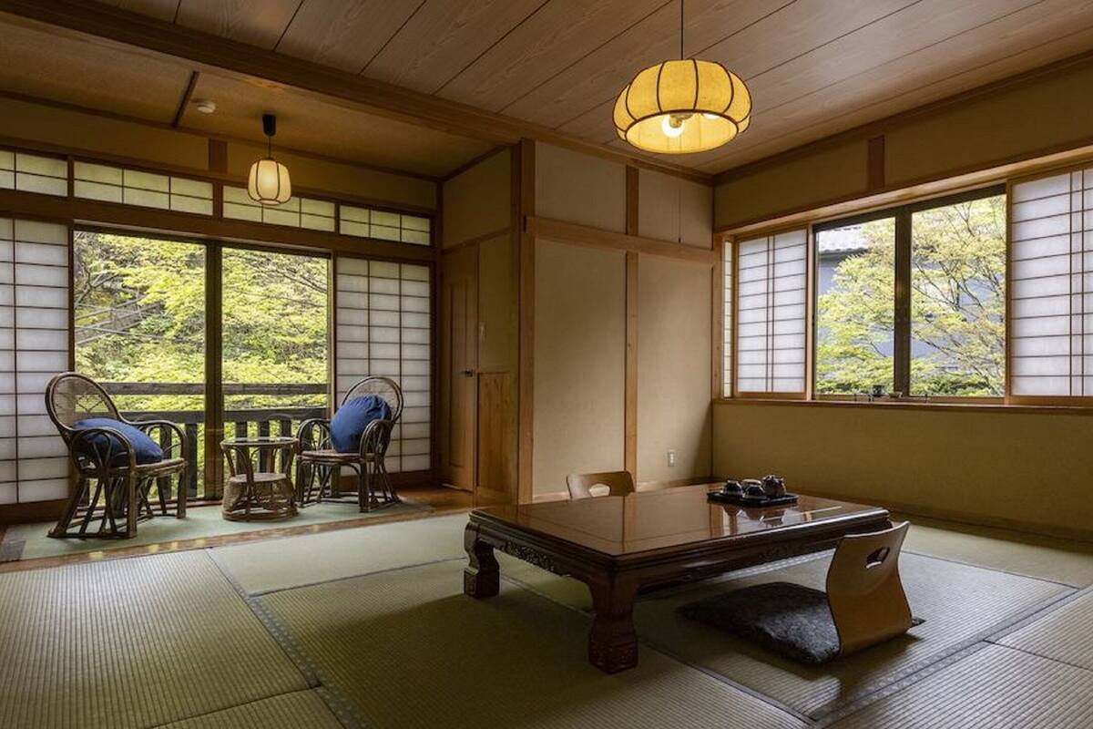 A traditional Japanese room with tatami flooring, a low wooden table, and shoji screens.