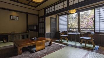 A traditional Japanese room with tatami flooring, a low wooden table, and sliding doors.