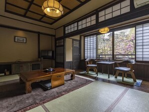 A traditional Japanese room with tatami flooring, a low wooden table, and sliding doors. - Okyakuya (Minamioguni)