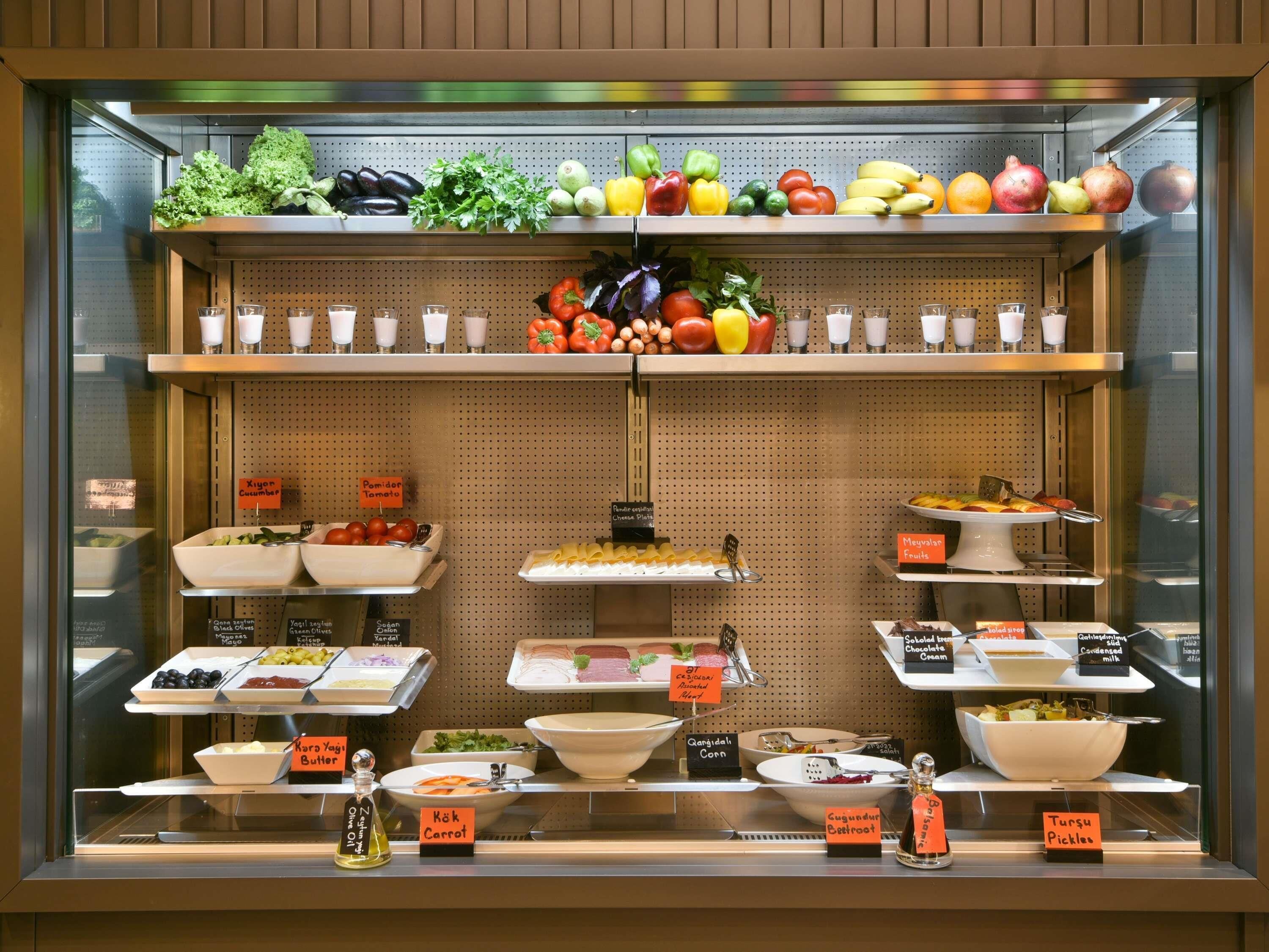 A food display case with various fruits, vegetables, and condiments.
