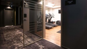Un gimnasio moderno con cintas de correr, una bicicleta estática y un banco para pesas.