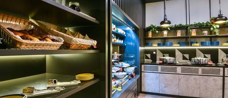 A buffet area with various food items and utensils.