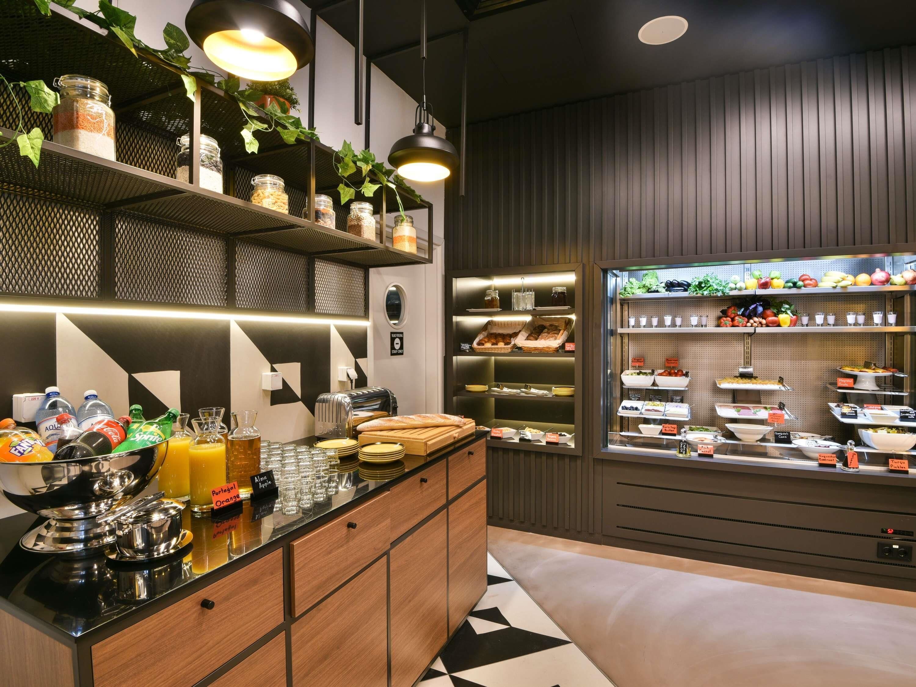 A breakfast bar with various food items, a coffee machine, and a fruit display.